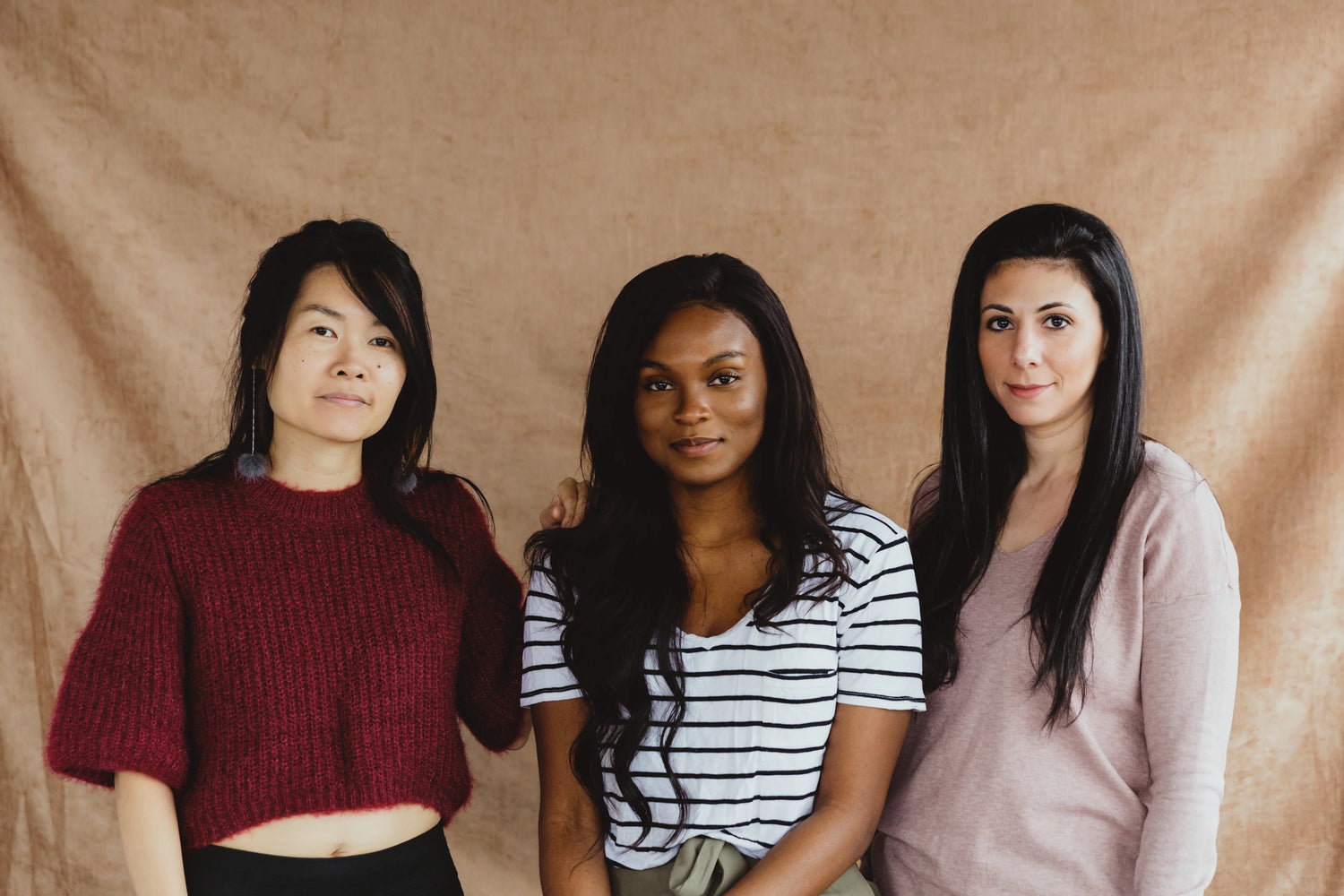 three-woman-stand-in-front-of-a-pink-backdrop.webp__PID:99d7177b-e0e0-478e-80aa-90592473af53